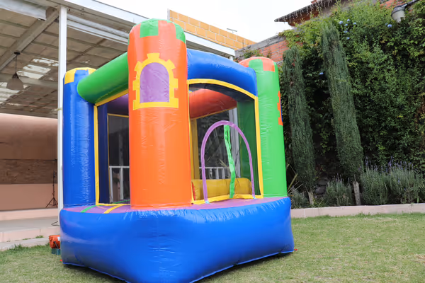 Mini castillo inflable junto a mesa de dulces ideal para baby shower