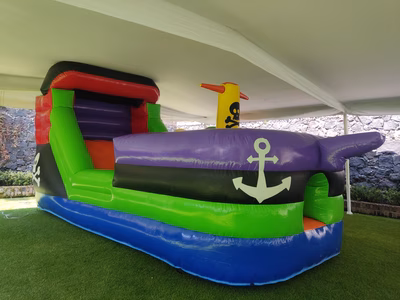 Renta inflable Barco Pirata CDMX - Vista completa instalado en jardín bajo carpa con tobogán